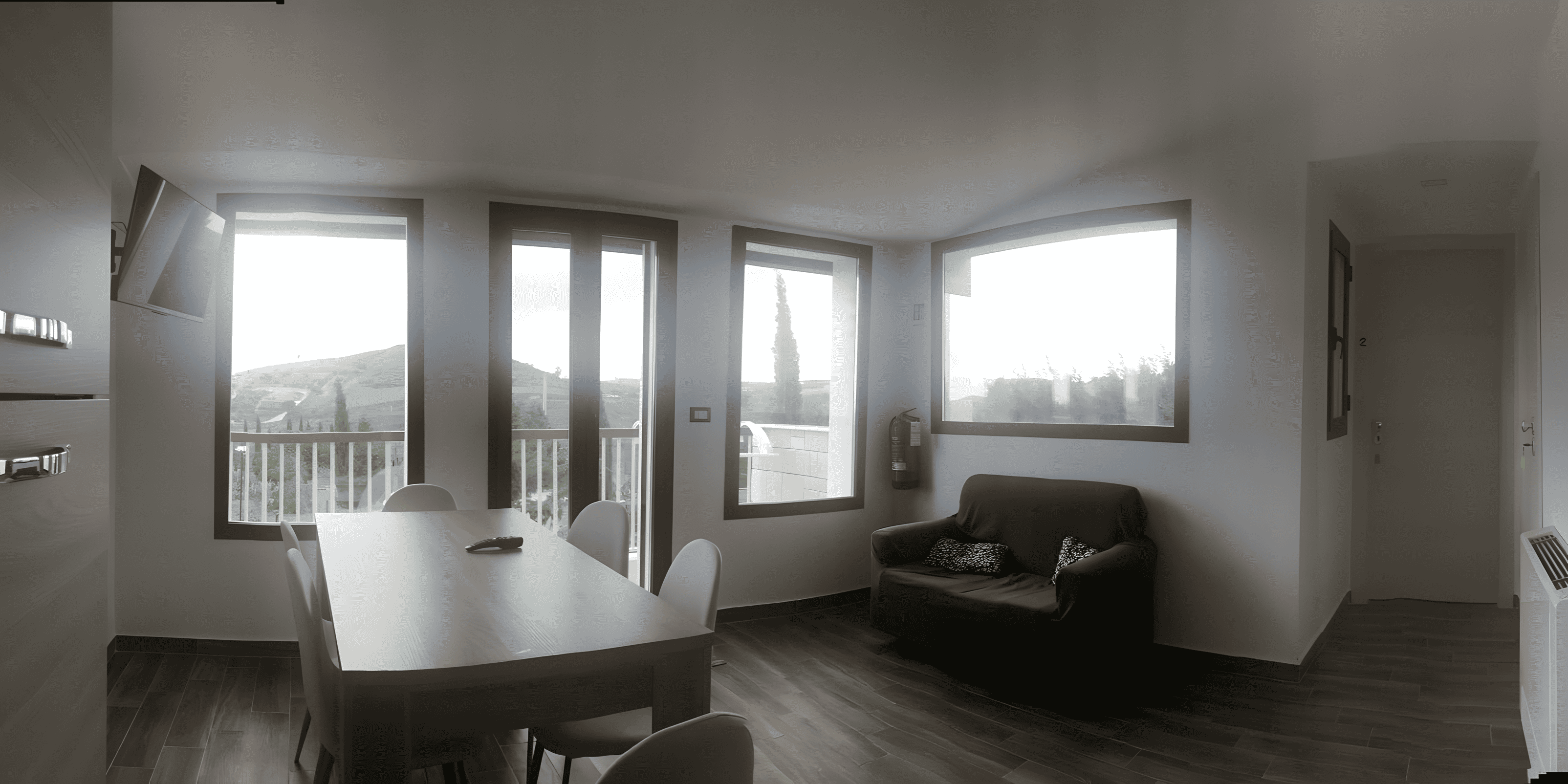 foto della stanza cucina con tavolo, sedie, televisione, divano e una bella vista