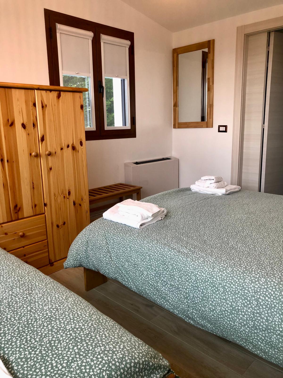 foto della camera da letto luminosa con un letto matrimoniale e un lettino